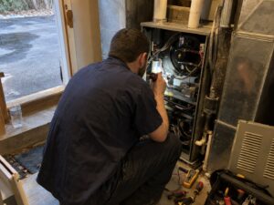 Inspecting the interior of an open furnace cabinet by Lexington Heating and Air