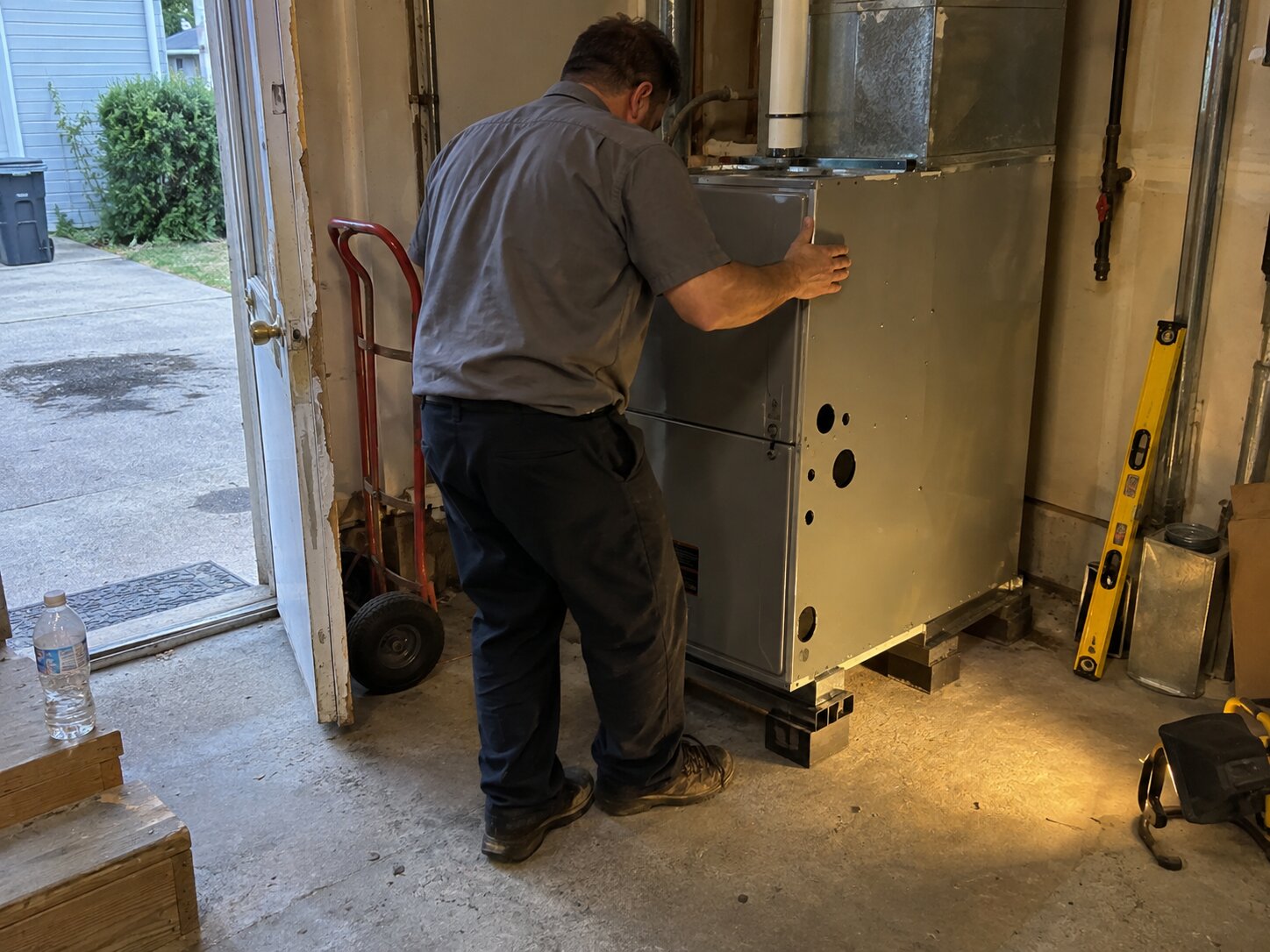 Setting a new furnace in place during installation by Lexington Heating and Air