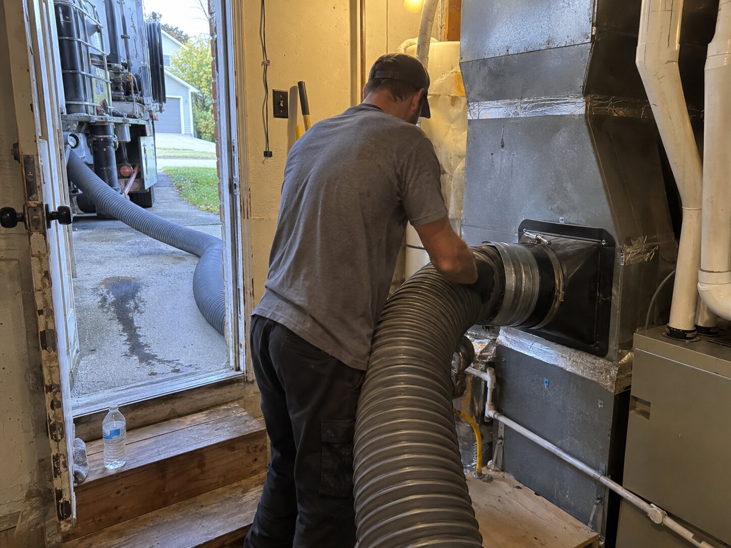 Truck-mount HEPA duct cleaning attached to a plenum by Lexington Heating and Air