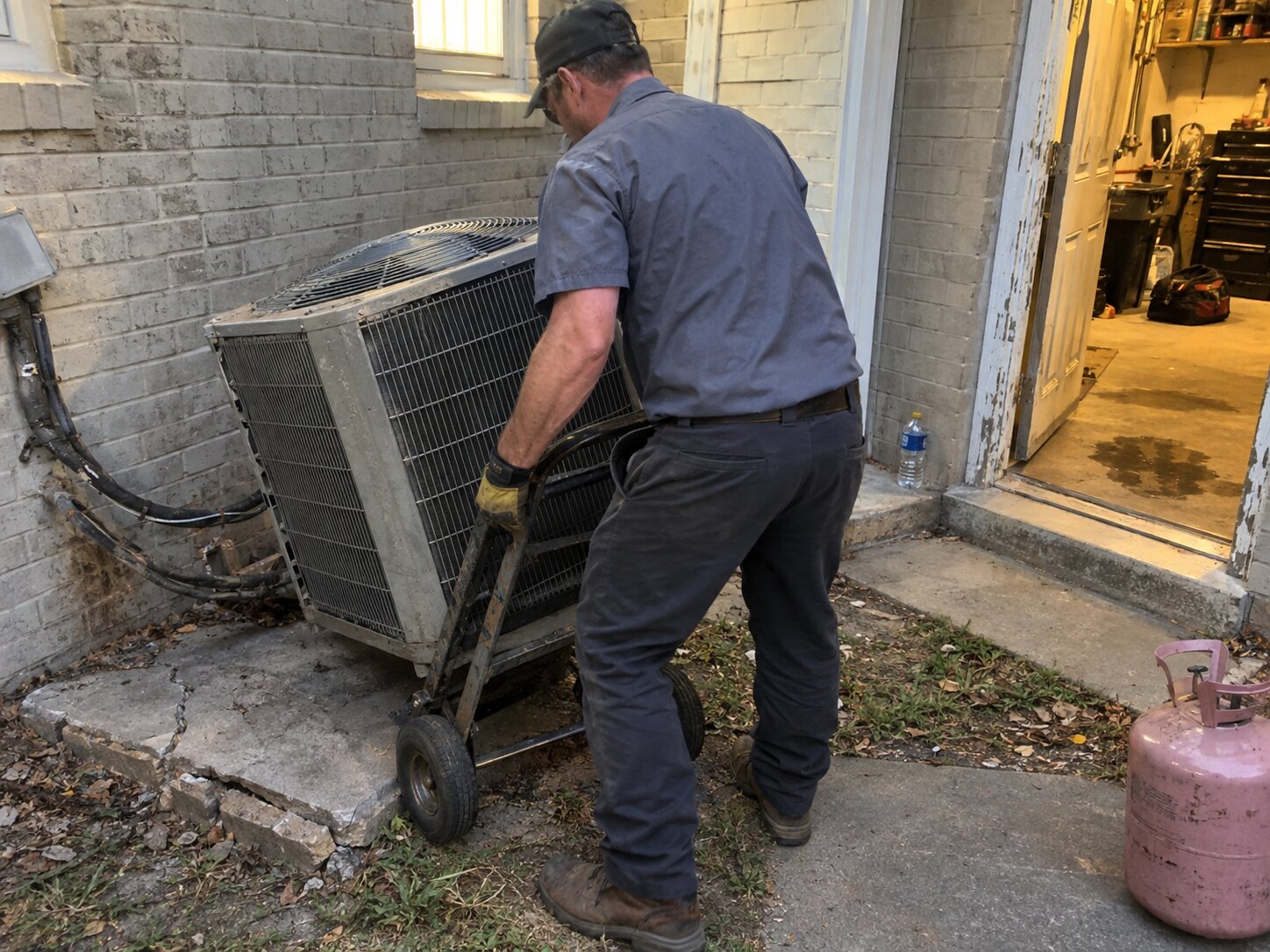 Removing an old condenser during a replacement in Installation by Lexington Heating and Air